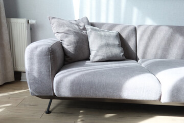 modern grey sofa with pillows in living room at home