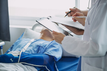 Man with broken arm in cast lying on bed in hospital. The emergency center treatment is plaster and hangs with sling for a further cure in an orthopedic clinic. Patient pain from accident injury.