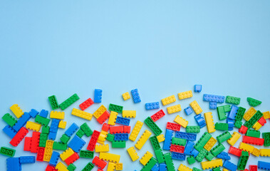 Multi-colored plastic cubes of a children's designer on a blue background, top view