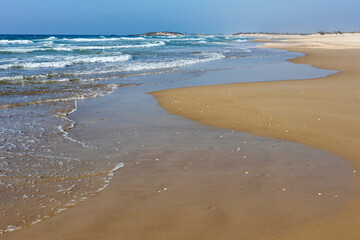 On a day of pleasant weather, the Mediterranean coastline boasts a sandy shore that beckons visitors to bask in the sun and enjoy the sea's soothing rhythm.