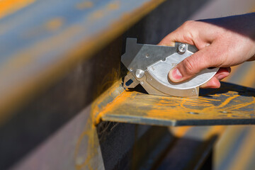 The inspector is measuring to fillet welds thickness with welding caliper (gauge).