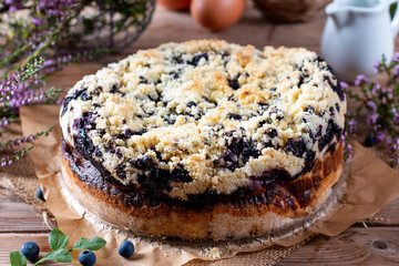 Fresh-baked blueberry cake on wooden table. Baked goods concept.