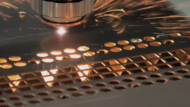 CNC laser cutting machine working with sheet metal with sparks at factory, plant - close up, slow motion. Metalworking, machining, industrial, technology and manufacturing concept