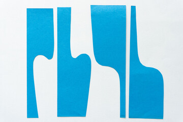 cut blue paper shapes with distinct wavy forms and straight edges on blank paper