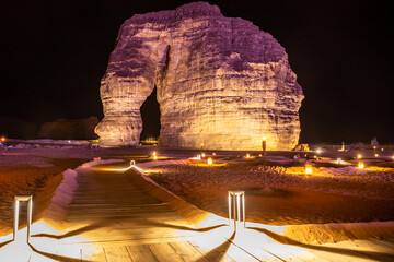 Illuminated sandstone elephant rock erosion monolith standing in the night desert, Al Ula, Saudi Arabia