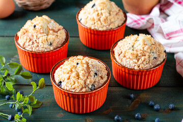 Blueberry muffins with powdered sugar and fresh berries on the green table.