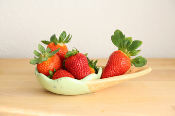 Red fresh tasty strawberries in clay bowl in form of ice cream cone on wooden table on white background copy space postcard strawberry
