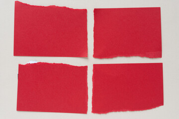 four red paper tiles on blank beige paper