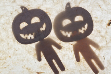 two halloween ornaments and stick figures set behind tissue paper - soft focus
