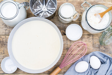 ingredients for making dough on a wooden table for pancakes, top view