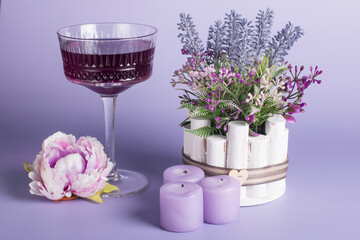 A glass glass-a creamer for drinks with colored drinks. Alcoholic fruit cocktail on a wooden background with candles, the concept of relaxation