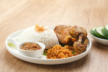 Bebek Goreng Kremes, served with chili sauce (sambal) and cucumber. Indonesian food
