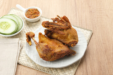 Bebek Goreng, served with chili sauce (sambal) and cucumber. Indonesian food
