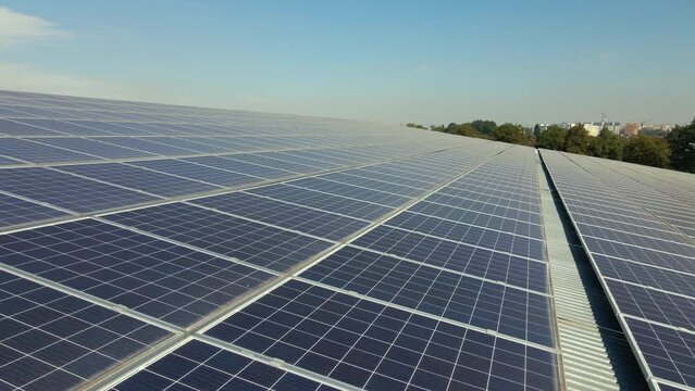 Blue photovoltaic solar panels mounted on industrial building roof for producing clean ecological electricity. Production of renewable energy concept