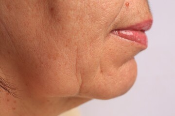 Closeup view of older woman on white background