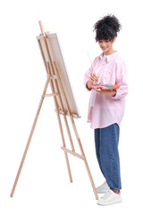 Young woman painting on easel with canvas against white background