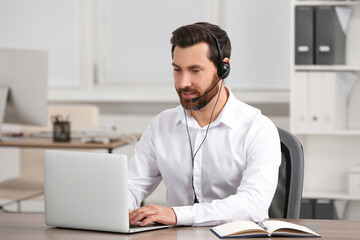Fototapeta premium Hotline operator with headset working in office