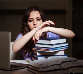 Young female student preparing for exams late at home