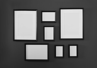Empty frames on black wall. Mockup for design