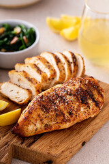 Grilled chicken with spice rub and lemon on a cutting board