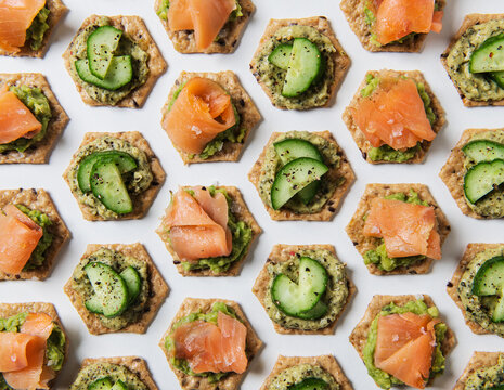 Appetizers of crackers with guacamole, cucumber and smoked salmon
