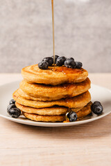 Stack of pancakes with blueberries and maple syrup