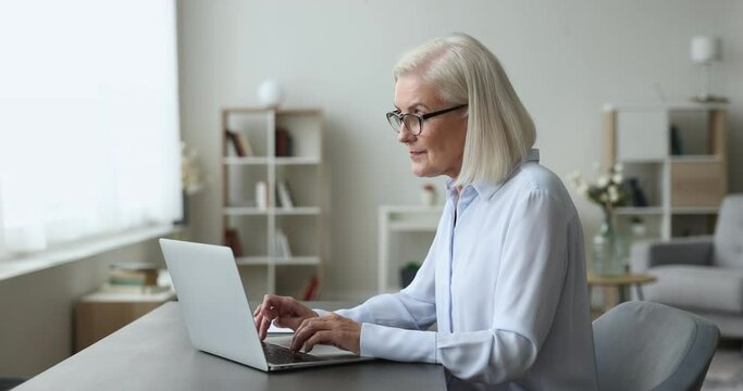 Overjoyed mature woman look at laptop screen, feels happy, online bet, lottery win, surprised by great news, make yes gesture, celebrate victory. Income increase, moment of success, business growth