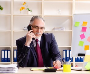 Aged man employee in conflicting priorities concept