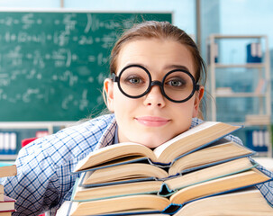 Female student with many books sitting in the classroom