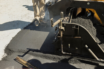 Paver machine used to pave asphalt during construction of new road steam roller used to place layers road