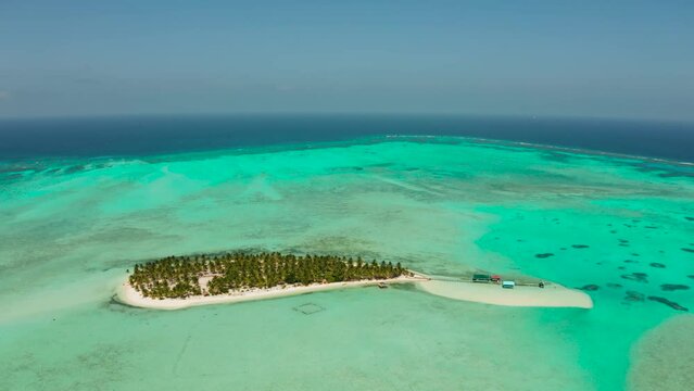 Tropical island in the ocean with palm trees on white sand beach. Onok Island, Balabac, Philippines. Summer and travel vacation concept