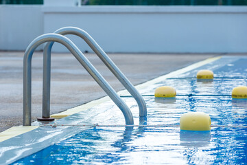 Ladder stainless handrails for descent into swimming pool. Swimming pool with handrail . Ladder of...