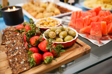elegantly arranged charcuterie board displaying various meats, cheeses, fruits, and nuts. It symbolizes the joy of abundance and shared experiences, emphasizing the importance of enjoying life