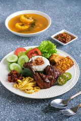 nasi uduk pecal ayam or coconut milk rice pecal chicken, traditional Indonesian food