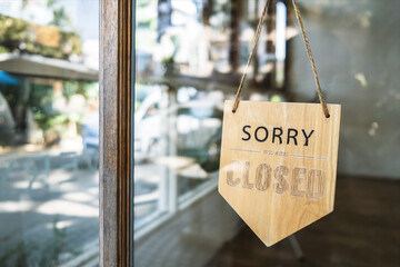 Sign text hangs on the entrance door of the shop, restaurant, cafe. That reads 