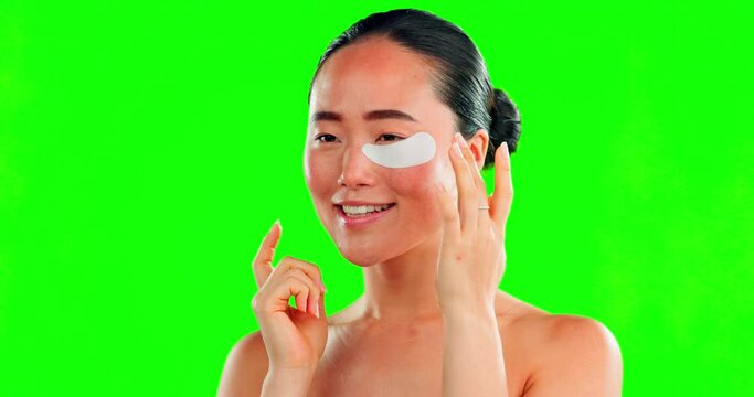 Face, skincare and Asian woman with eye patches on green screen in studio isolated on a background mockup. Dermatology, cosmetics and happy female model apply facial mask for healthy skin treatment.