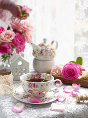 Obraz na płótnie Canvas Herbal tea with roses on white wooden table