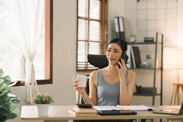 The millennial businesswoman from a startup is seen working with financial report paperwork in her home office, illustrating the concept of financial advising teamwork and accounting.