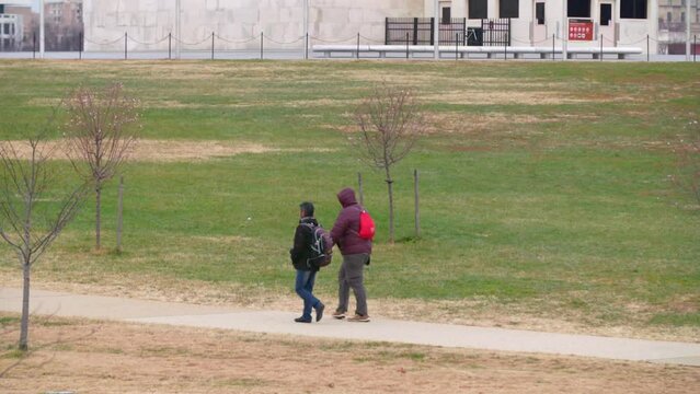 Slow Motion Lockdown Shot Of Friends Walking Together In Park During Winter - Washington, District of Columbia