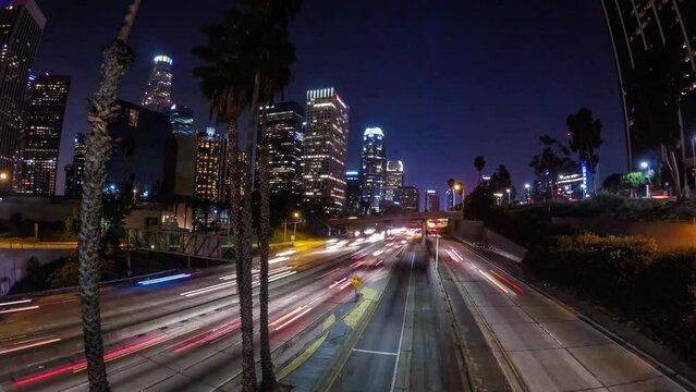 Panning Time Lapse Shot Of Long Exposures Of Cars Moving On Roads In Modern Illuminated City At Night - Los Angeles, California