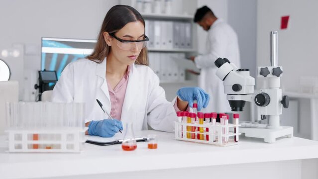 Scientist, woman and blood sample analysis in a laboratory for medical research. Science, dna testing and lab chemistry check with a female pharma and hospital employee with microscope and test tube