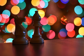 chess pieces in front of Christmas lights