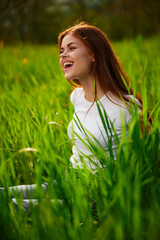 portrait of a laughing red-haired woman sitting in the grass