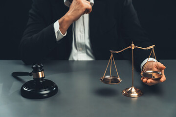 Focus symbols of justice, gavel hammer and scale balance on blurred background of thoughtful lawyer...