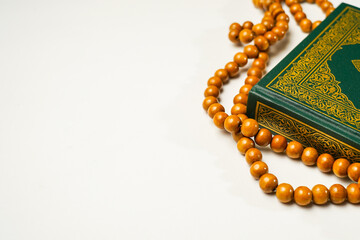 The Holy Al Quran with written arabic calligraphy meaning of Al Quran and rosary beads or tasbih on...