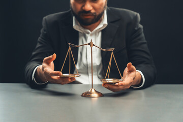 Lawyer or judge in formal black suit hold unbalanced scale with expression of disappointment trying...
