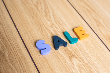 Top view of letter cubes or blocks of "SALE" on wooden background. 