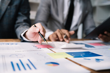 Business team or financial data analysts working with tablets and laptop computers and data graphs together. Plan to analyzing projects in the office.