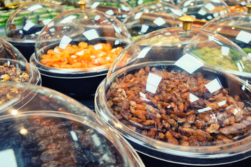Raisins, dates, dried apricots and other dried fruits and nuts on a store counter