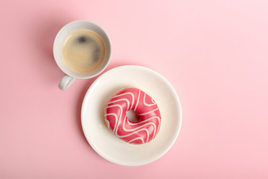 Cup Of Hot Aromatic Coffee And Pink Glazed Strawberry Donut On White Round Plate From Above On Pink Background. Sweet Tasty Breakfast Or Fast Snack Time. 